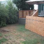 In the rear yard an added deck and redwood railings are under construction.