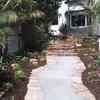 A flagstone ribboned concrete walkway with stacked stone steps takes a route away from the garage and begins at the side walk. Now the visitors do not have to enter the house through the driveway.